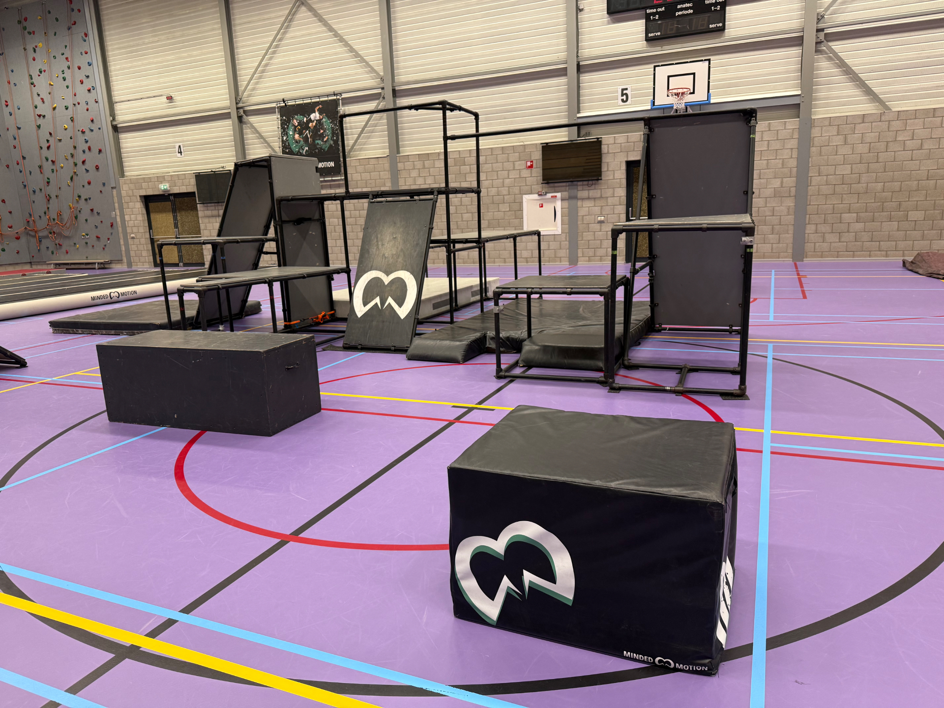 Impressie van een freerun clinic op school — sporthal met parkour-opstelling van Minded Motion